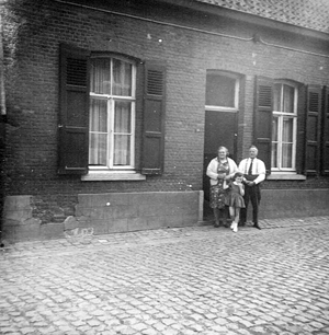 Vader en moeder Beirens voor hun oud huis in de Langestraat. Het meisje is Bernadette De Kimpe